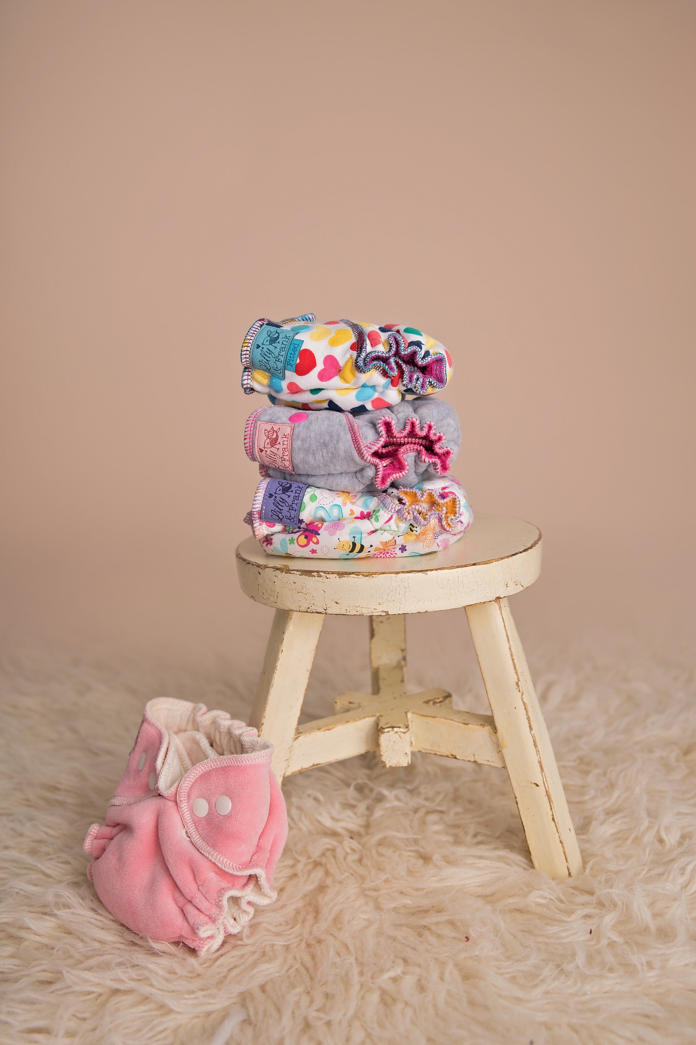 newborn cloth diapers stacked on a small stool