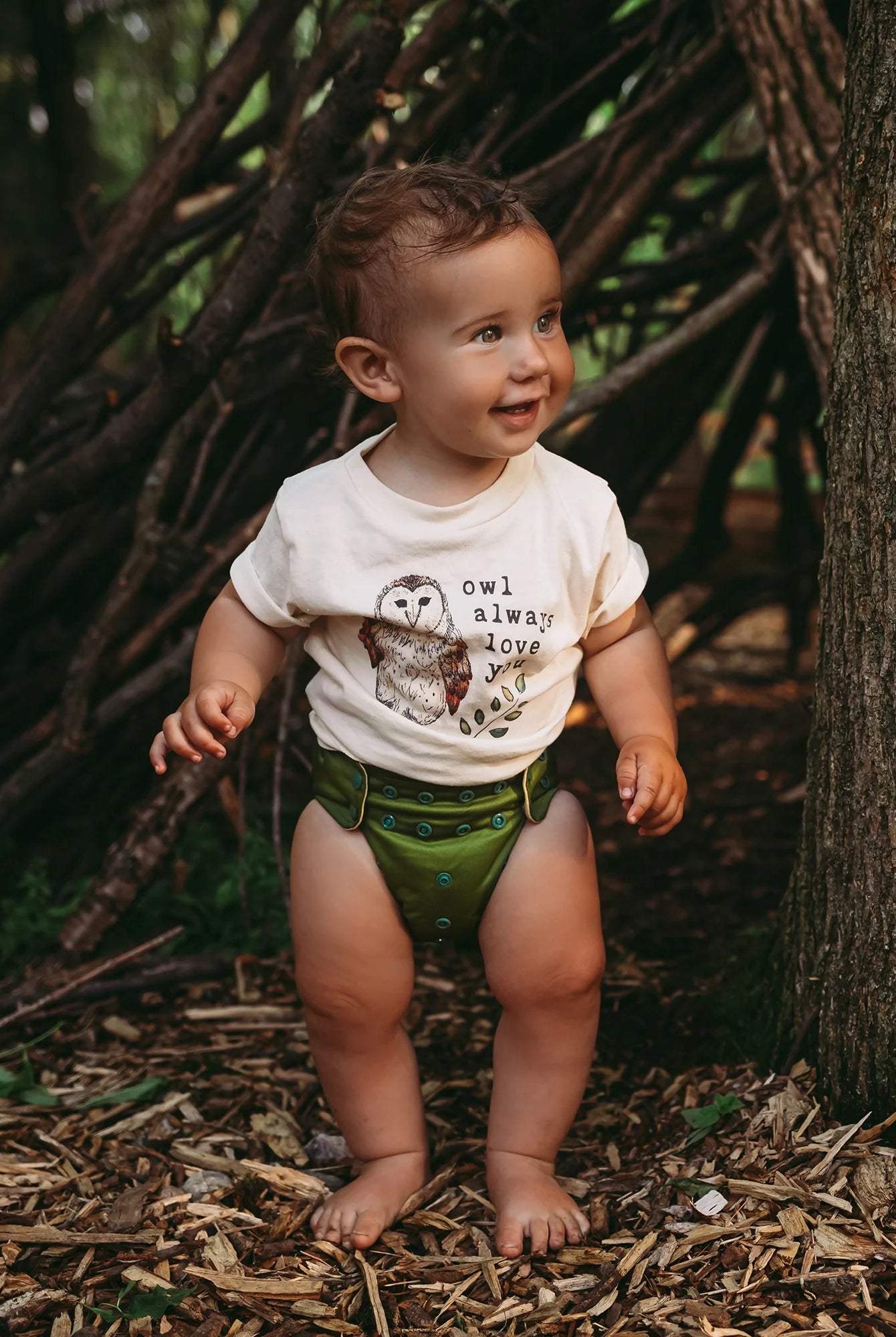 baby wearing all in one cloth diaper in a dark green solid print
