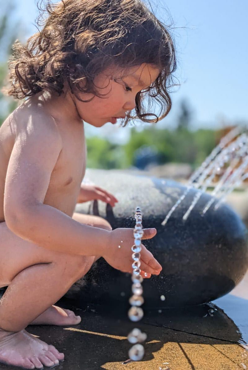 toddler wearing lilly and frank training underwear playing in water
