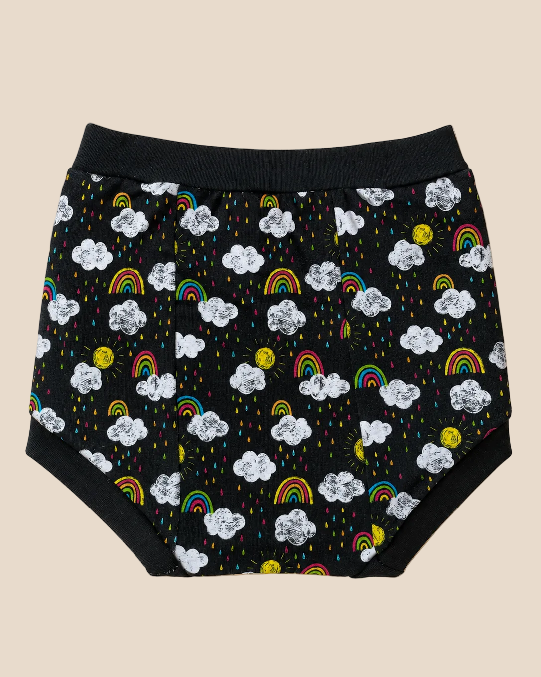 Black diaper cover with a playful cloud, rainbow, and sun print, laid flat on a solid beige background.