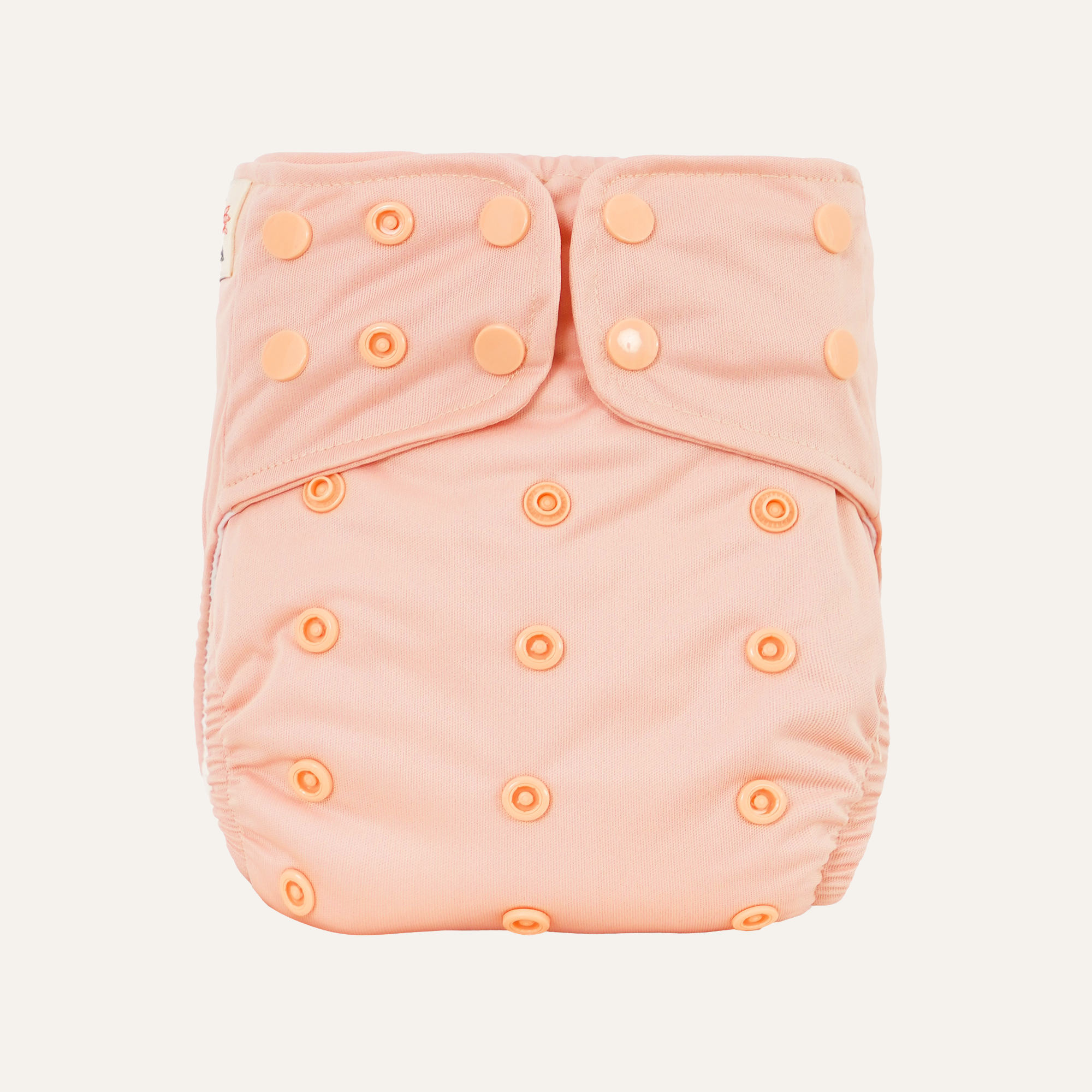 Pink cloth diaper cover with button closures on a light gray background