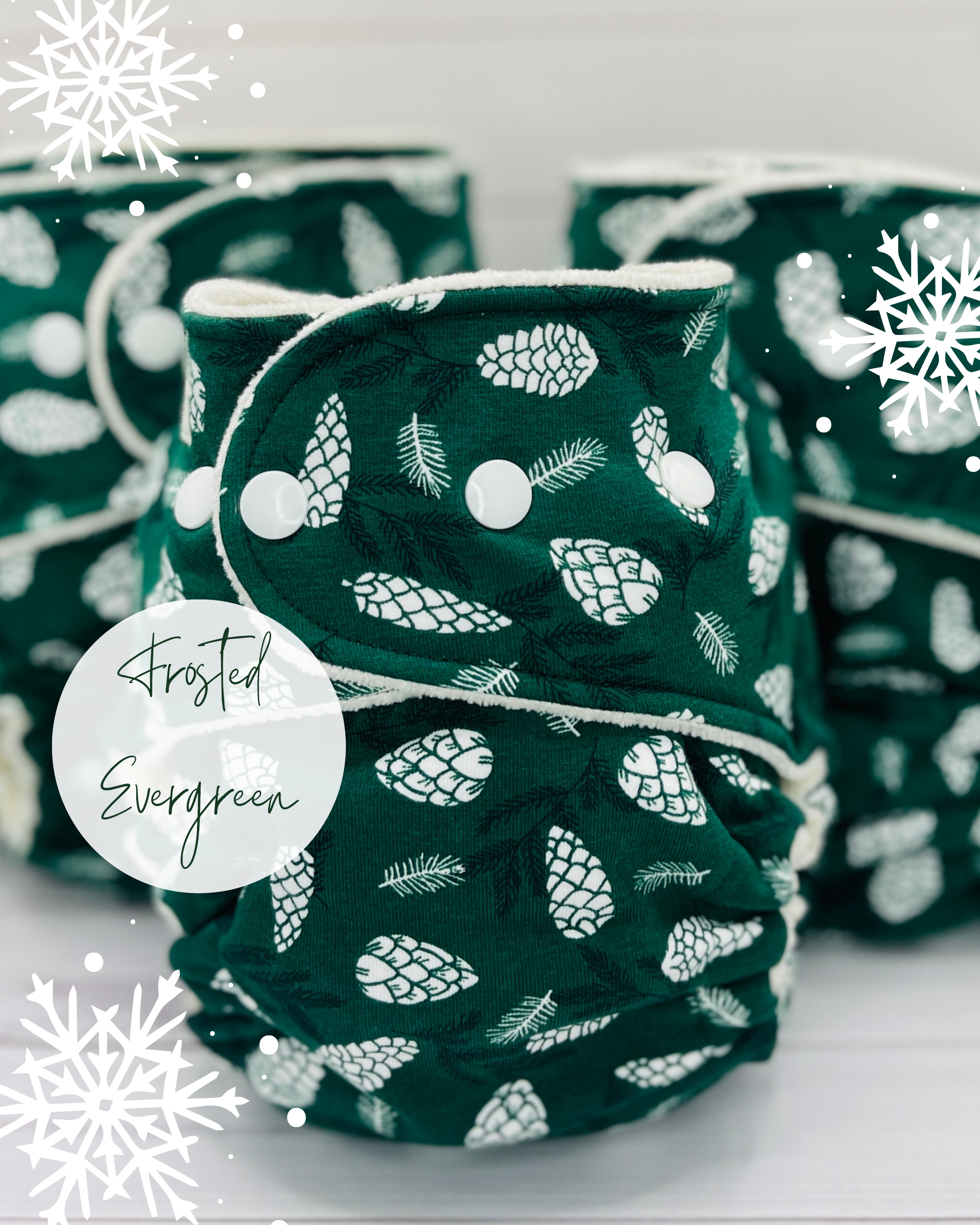 group picture of dark green fitted diapers with white pinecones