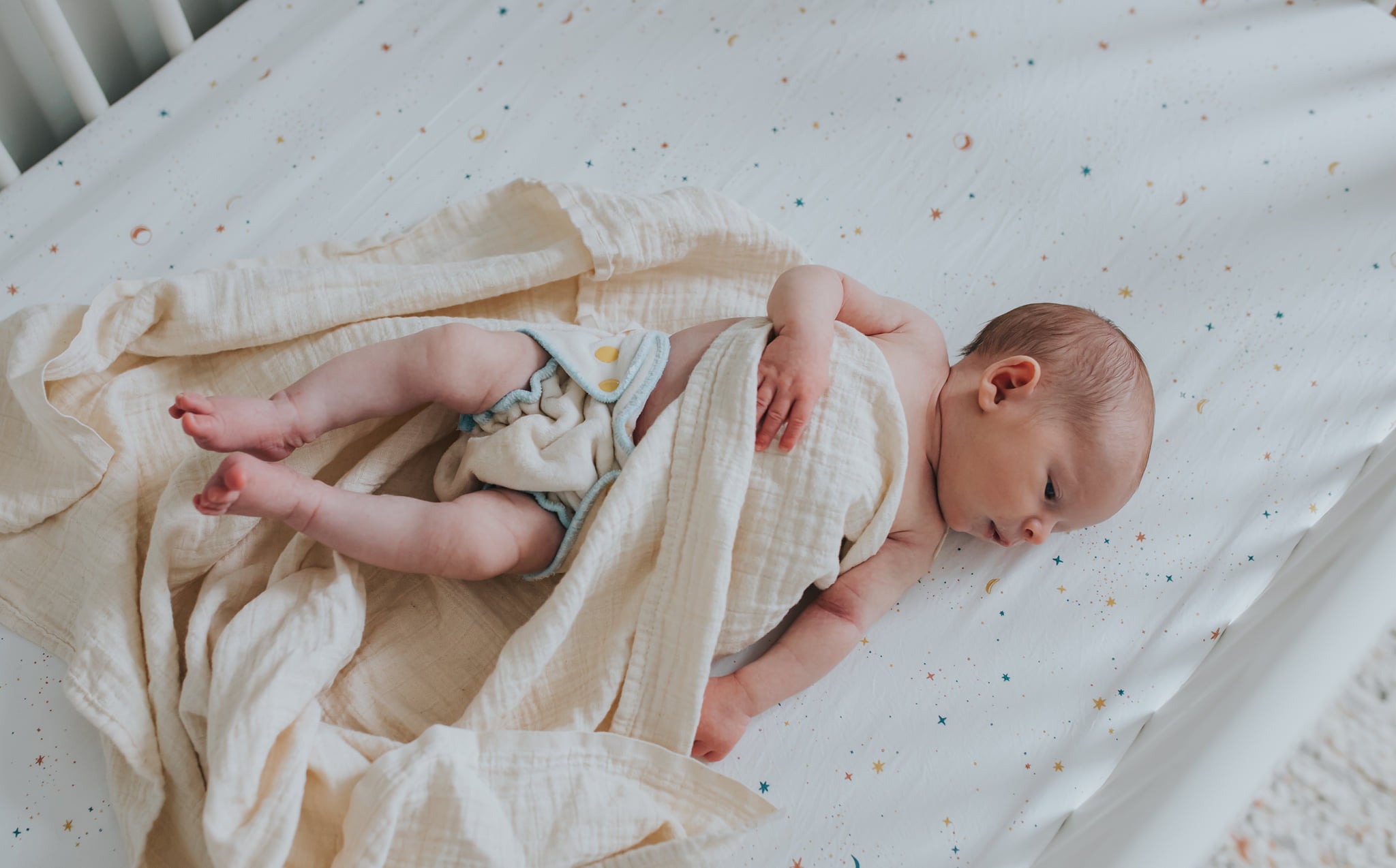 newborn baby wearing a newborn velour fitted cloth diaper