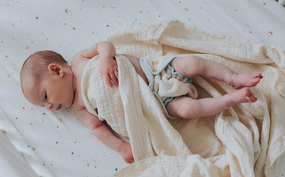 newborn baby wearing a newborn velour fitted cloth diaper