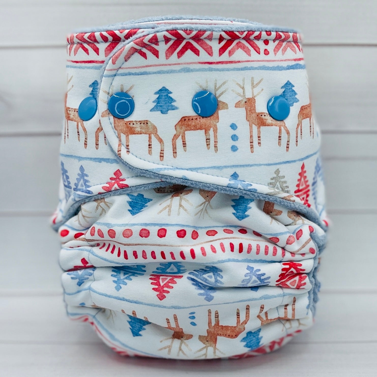 Folded cloth diaper with deer and snowflake pattern on a white background