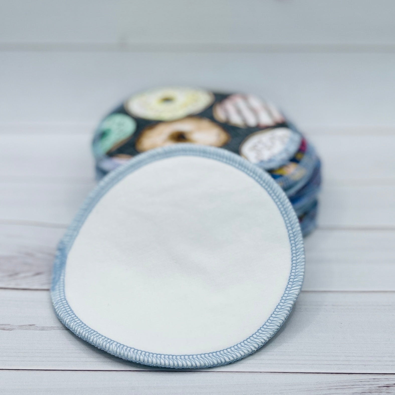 Reusable nursing pads with a donut pattern on a wooden surface