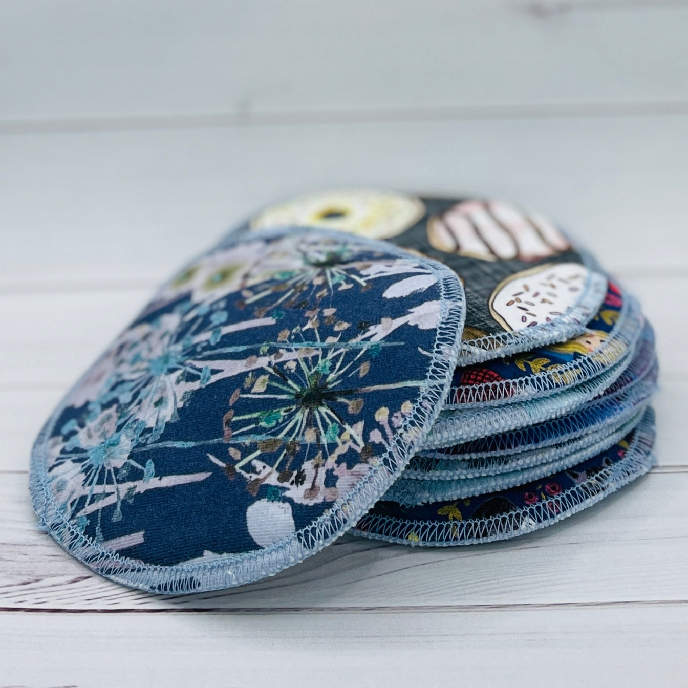 Set of floral-patterned pads on a white wooden surface