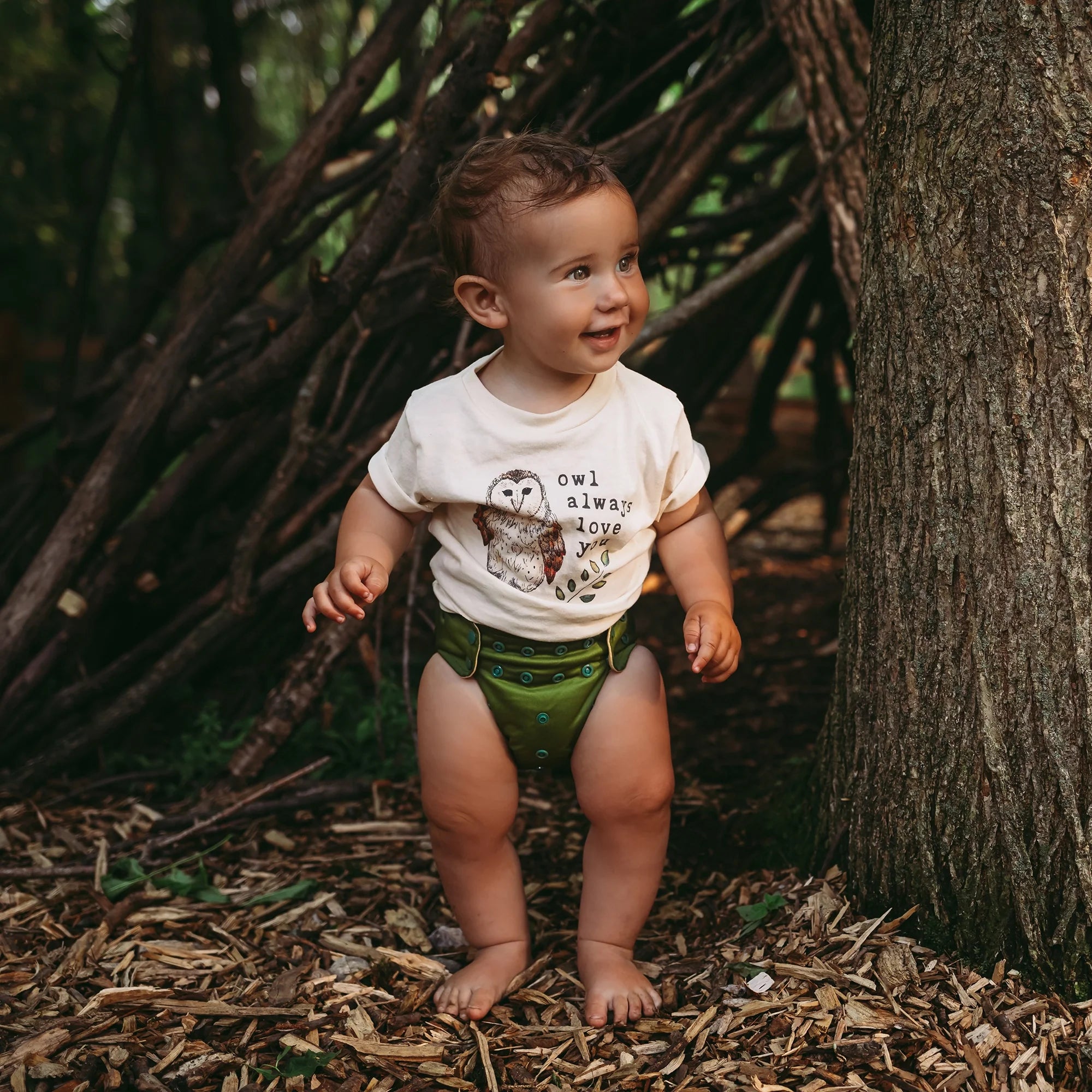 baby wearing all in one cloth diaper in a dark green solid print
