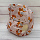 Two baby diapers with fox pattern on a wooden surface