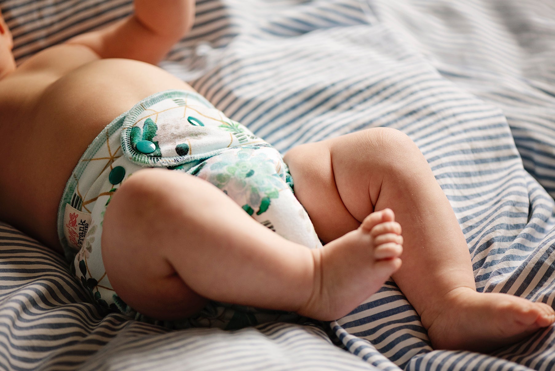 Fitted cloth diapers offering full absorbency from waist to leg