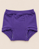 A pair of solid purple baby briefs laid flat on a light beige background.