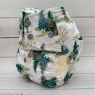 Reusable diaper with bear and forest pattern on a wooden surface
