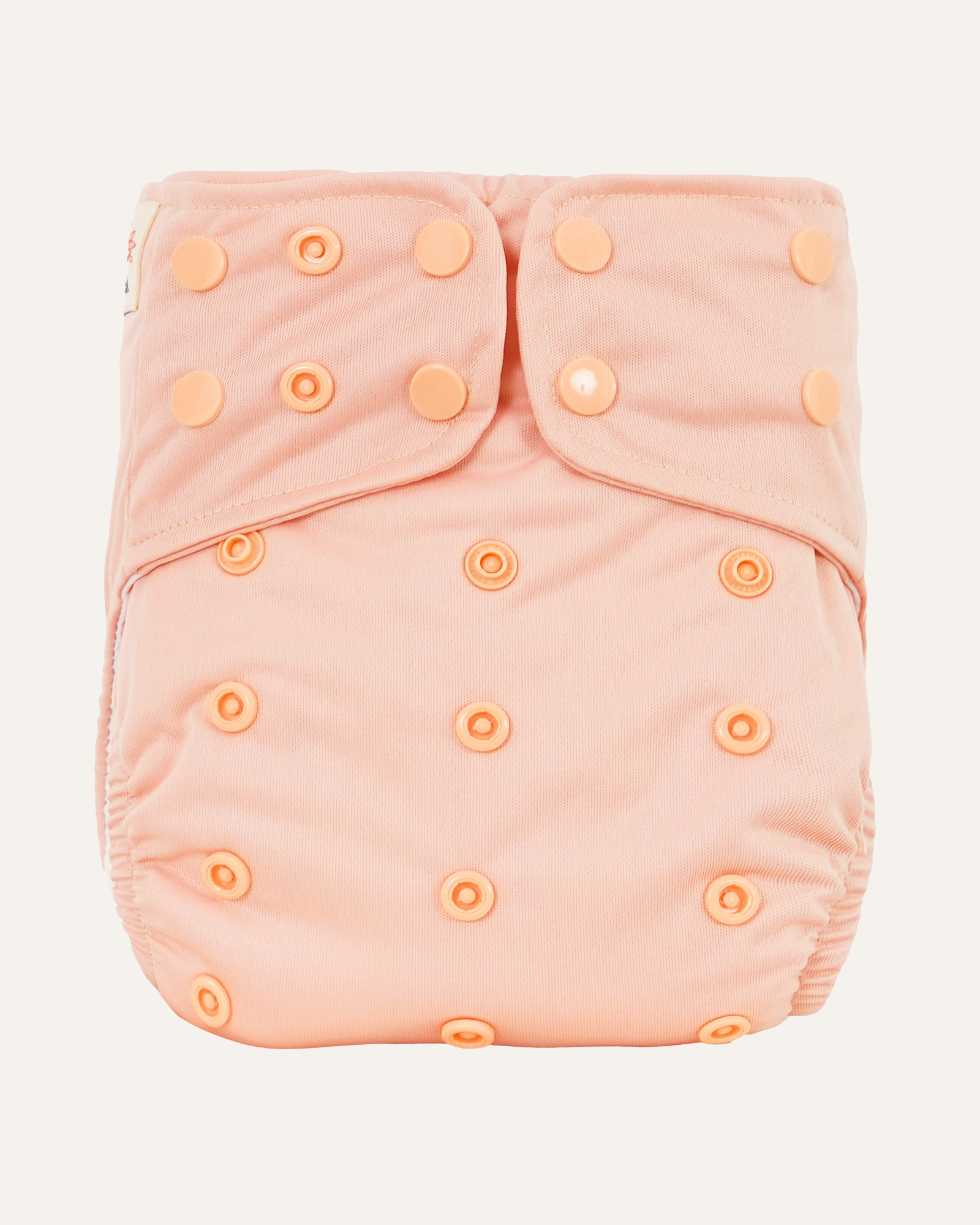 Pink cloth diaper cover with button closures on a light gray background
