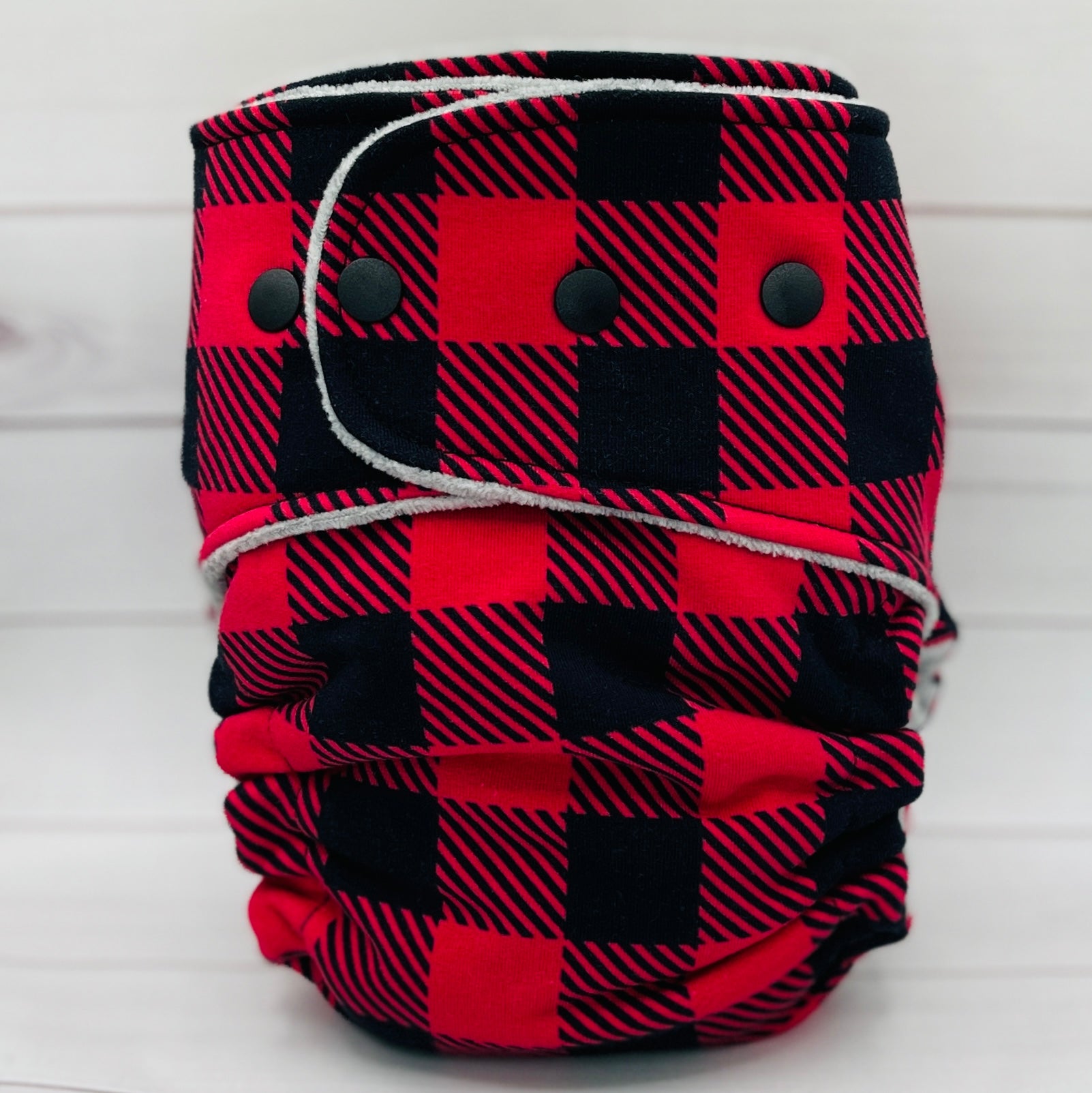 Red and black checkered cloth diaper on a white background