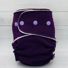 Purple cloth diaper with white trim and purple buttons on a white background
