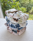 stack of 3 print fitted cloth diapers on a table