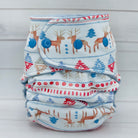 Stack of patterned diapers with deer and tree design on a light gray background