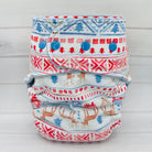 Three patterned cloth diapers stacked on a light gray background