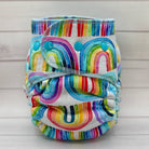 Colorful rainbow-patterned cloth diaper on a light wooden background