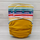 yellow and rainbow striped cloth diaper on a wood table