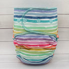 Colorful striped cloth diaper on a light wooden background