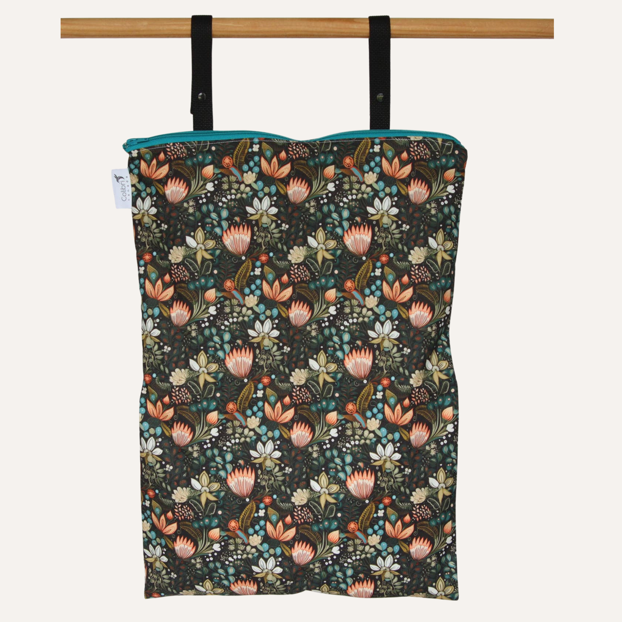 Floral-patterned bag hanging on a wooden rod against a white background